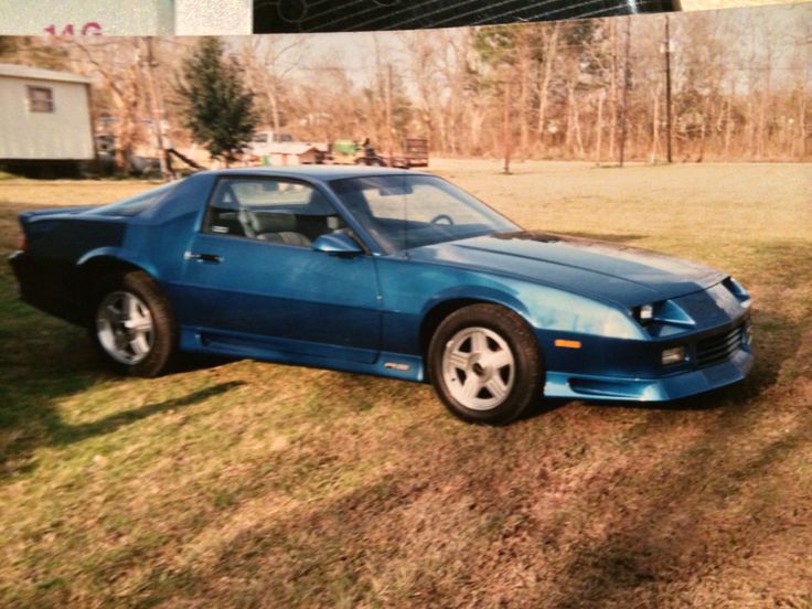 a blue sports car parked in the grass