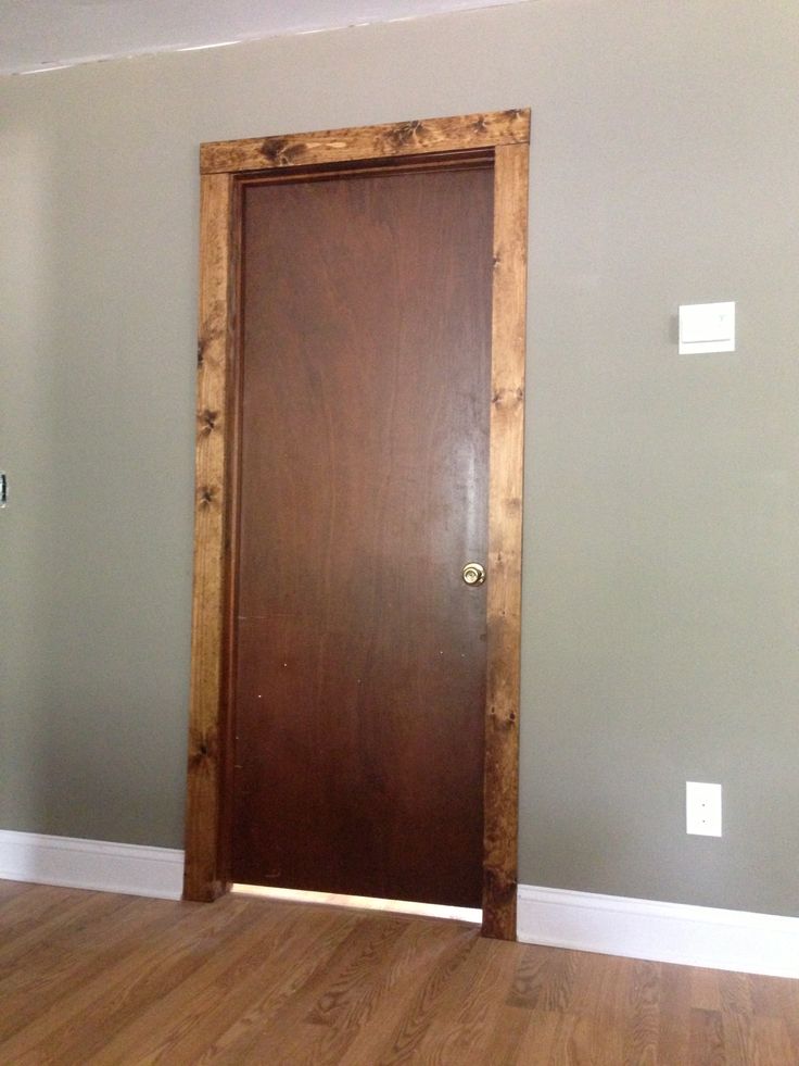 an empty room with a wooden door and hard wood floor