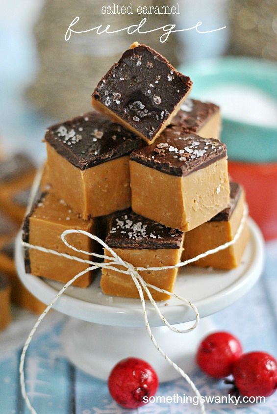 chocolate fudge bars stacked on top of each other with cranberries in the background