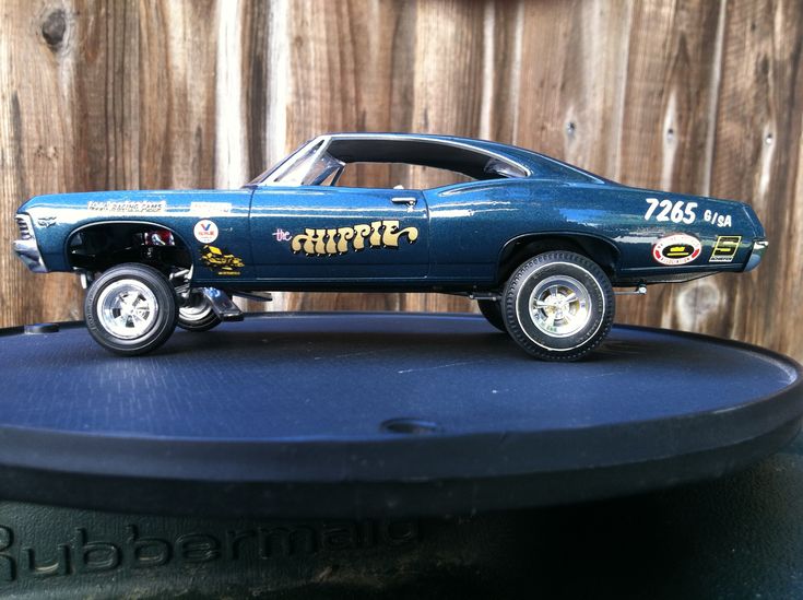 a toy car is sitting on top of a round table in front of a wooden fence