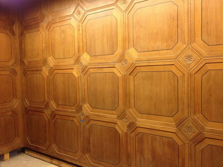 an unfinished room with wood paneling on the walls