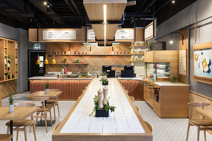 the interior of a restaurant with wooden tables, chairs and counter tops in front of it