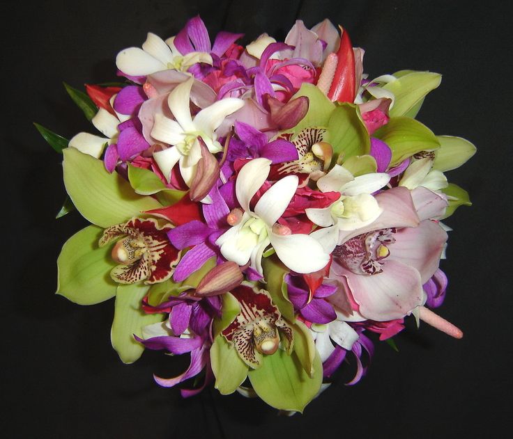 a bouquet of purple and white flowers on a black background