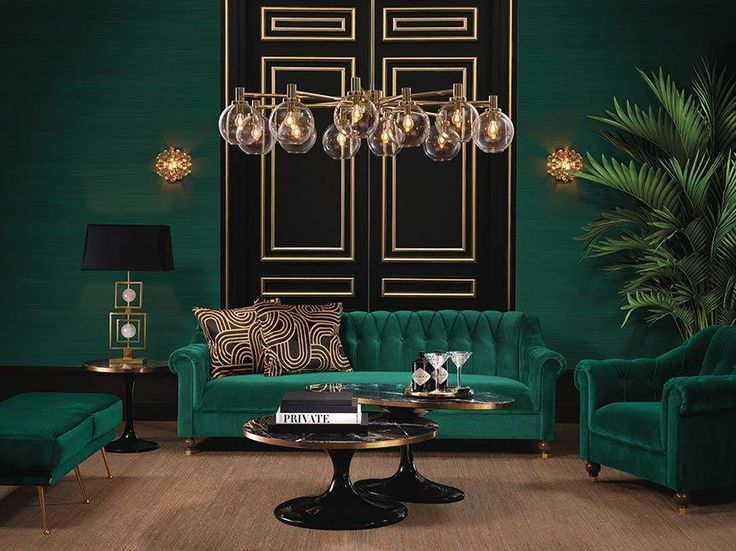 a living room filled with green couches and chairs in front of a black door