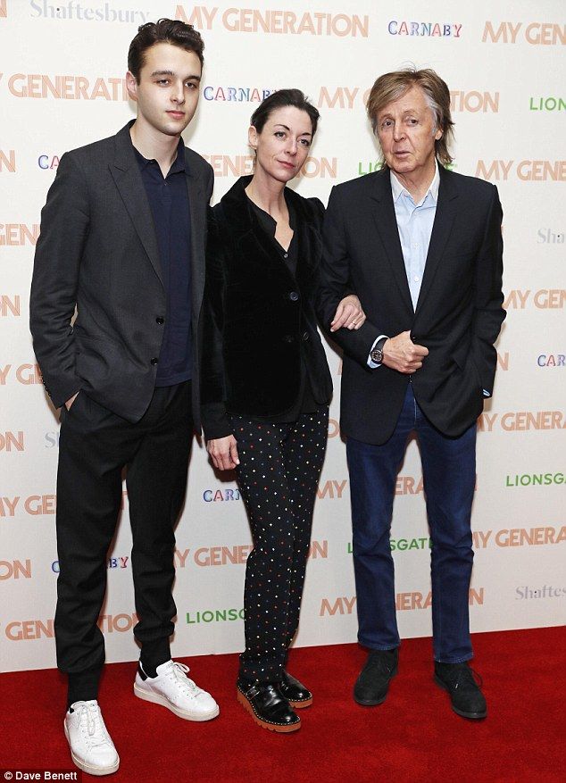 three people standing next to each other on a red carpet