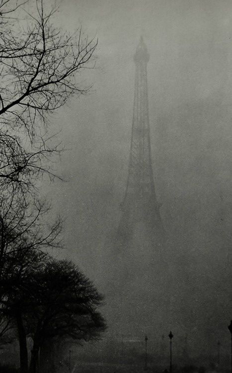 the eiffel tower is in the foggy sky