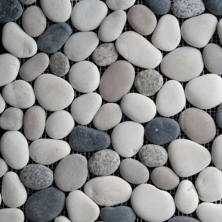 several white and black rocks are arranged on a wire mesh fence with the words seashore tile written below them