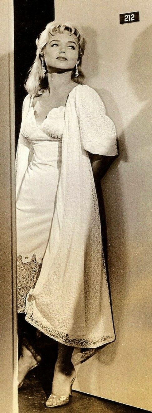 an old photo of a woman leaning against a wall