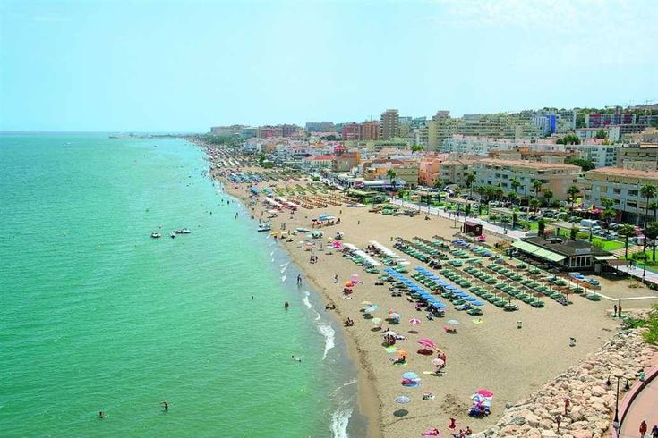 an aerial view of a beach with many umbrellas and people on the sand near the water