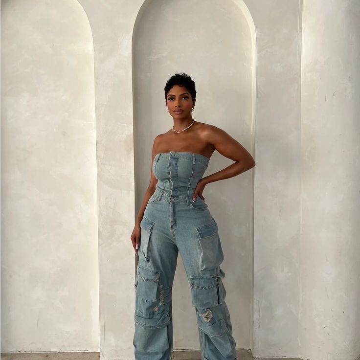 Brand New The Jumpsuit You Didn't Know You Needed! This Denim On Denim Jumpsuit Is The Epitome Of Perfection. With Its Unique Cut And Fit, You’re Sure To Make A Statement In This Set. Its Pre-Cinched Waist And Tailored Fit Make For The Perfect Silhouette. Wear “Jaden” With A Pair Of Heels Or Boots For The Ultimate Fall Vibes. This Jumpsuit Runs Oversized. As It's A Boyfriend Jean Fit. If You Would Like It To Fit Tighter, Size Down When Purchasing. Denim Jumpsuit Photoshoot, Fitted Denim Cargo Jeans For Summer, High Waist Fitted Cargo Jeans In Medium Wash, Fitted High Rise Cargo Jeans For Summer, Fitted High Waist Medium Wash Cargo Jeans, Fitted Dark Wash Cargo Jeans For Summer, Fitted High Waist Light Wash Cargo Jeans, High Waist Fitted Light Wash Cargo Jeans, Fitted Blue Cargo Jeans For Summer