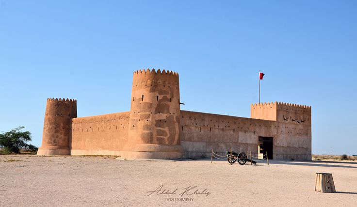 an old brick building with a flag on top and a bike parked in front of it