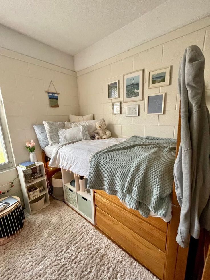 a bedroom with a bed, dresser and pictures on the wall