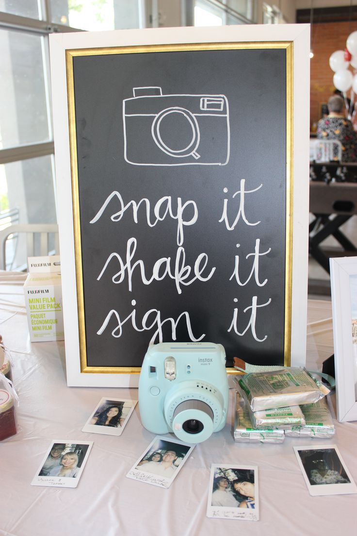 a camera sitting on top of a table next to a sign that says snap it shake it sign it