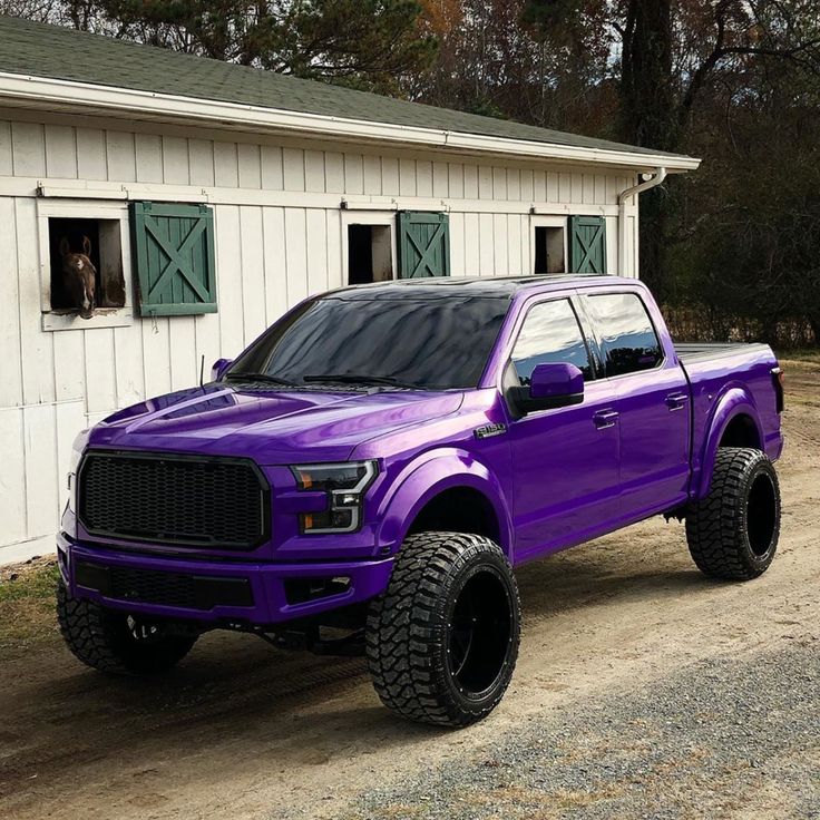 a purple truck parked in front of a white building