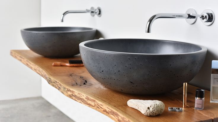 two black bowls sitting on top of a wooden counter