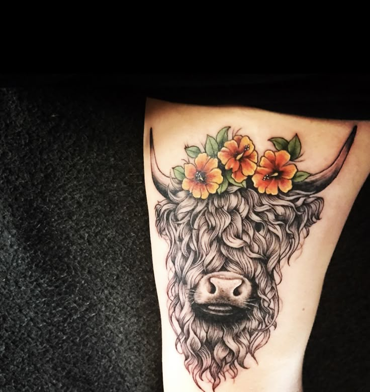 a cow with flowers on it's head is shown in this tattoo style photo