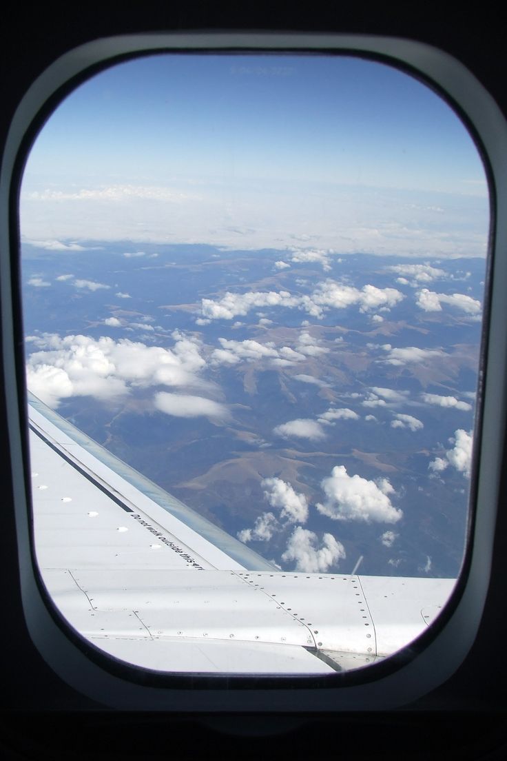 an airplane window looking out at the clouds