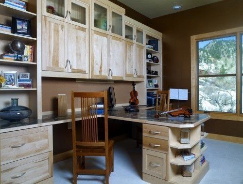 a home office with wooden cabinets and desk in front of large window overlooking the mountains