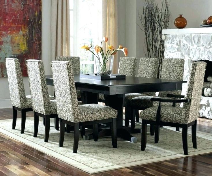 a dining room table with chairs around it and a rug on the floor next to it