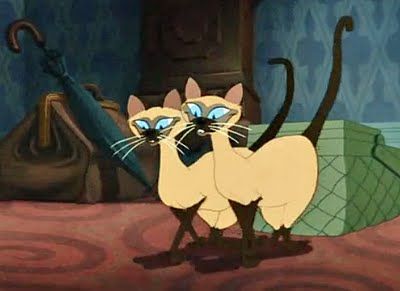 two cartoon cats standing next to each other on a bed with an umbrella in the background