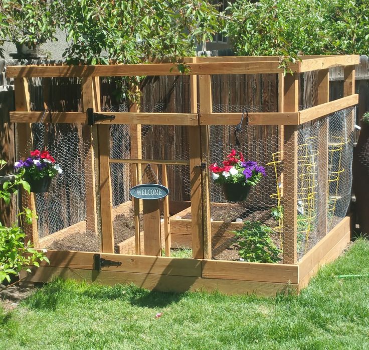 an outdoor chicken coop with flowers in it