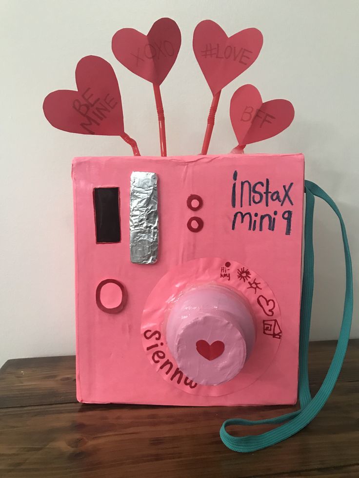 a pink polaroid with hearts attached to it