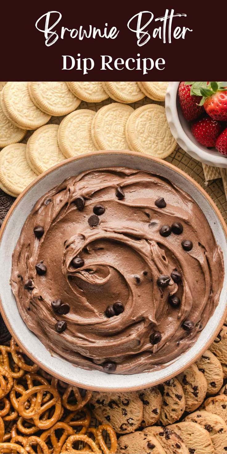 a bowl filled with chocolate dip surrounded by cookies and pretzels