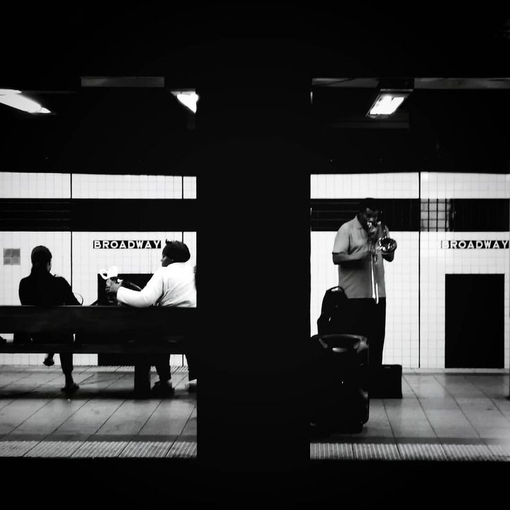 two people sitting on a bench in a train station