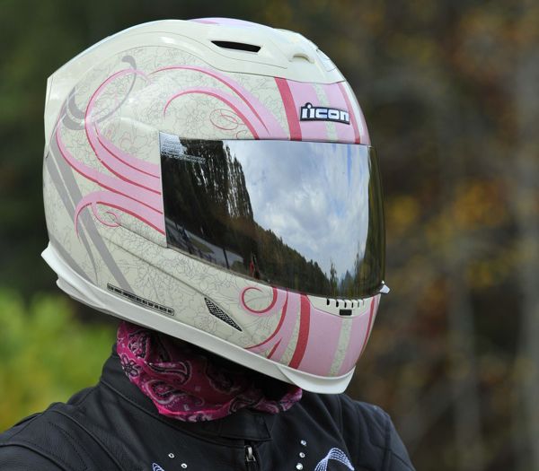 a person wearing a motorcycle helmet with trees in the background