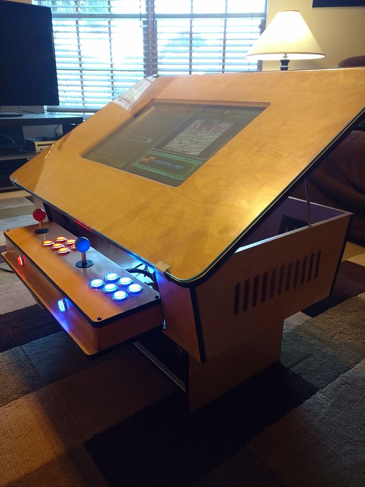 a coffee table with an arcade system built into it's sides and lights on