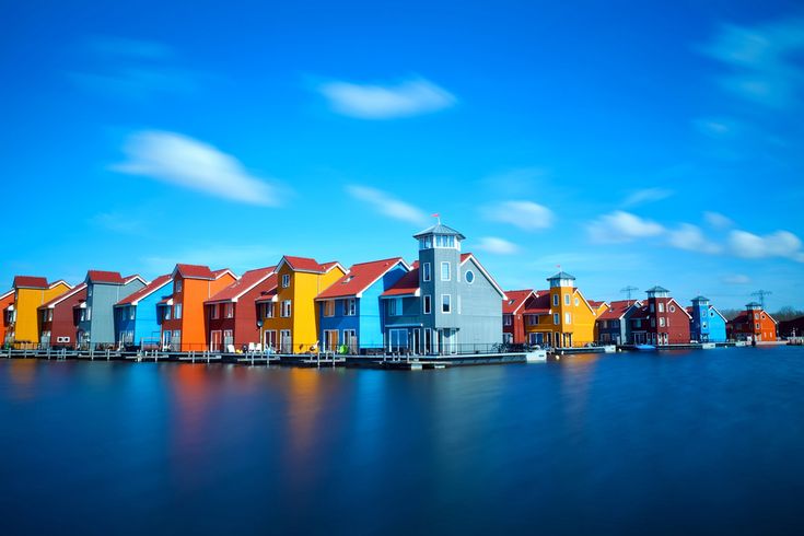 a row of colorful houses sitting on top of a body of water