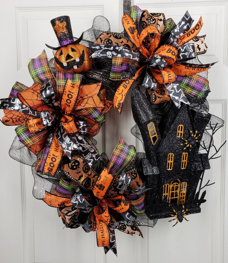 a halloween wreath on the front door decorated with black and orange ...