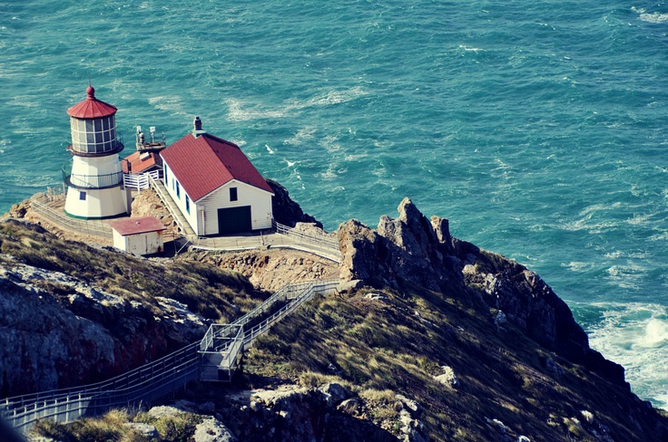 an aerial view of a lighthouse on top of a cliff