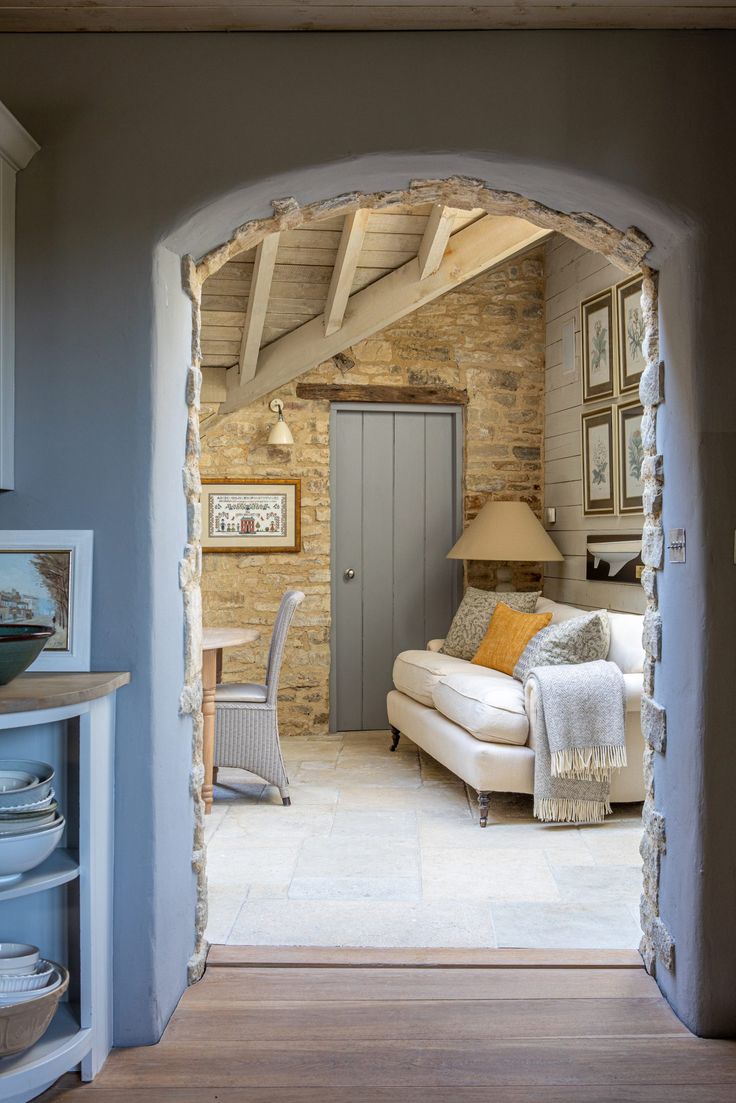 an open doorway leading to a living room with a couch and chair in it's center