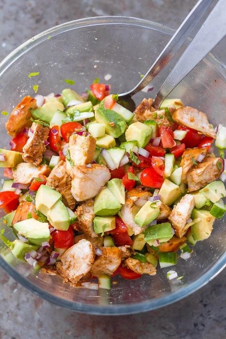 a glass bowl filled with chopped vegetables and meat