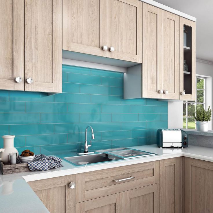 a kitchen with wooden cabinets and blue backsplash tiles on the counter top,