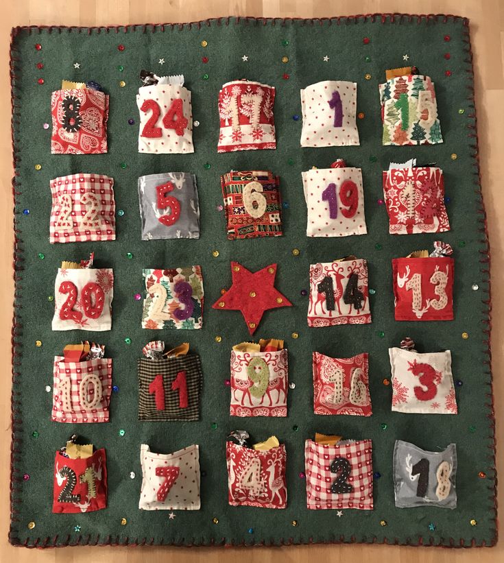 a quilted wall hanging with christmas decorations on it's sides and numbers in the middle