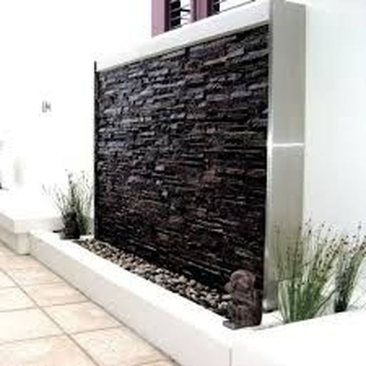 an outdoor fountain with rocks and plants in it