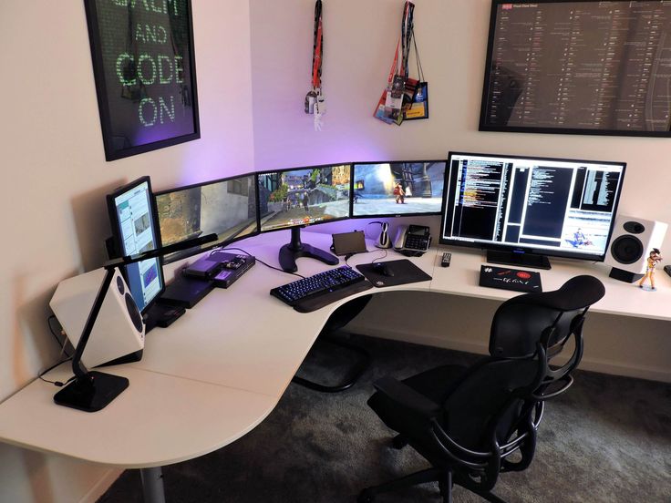 a computer desk with multiple monitors and keyboards