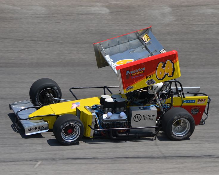 a man driving a race car around a track on top of a flat tire course