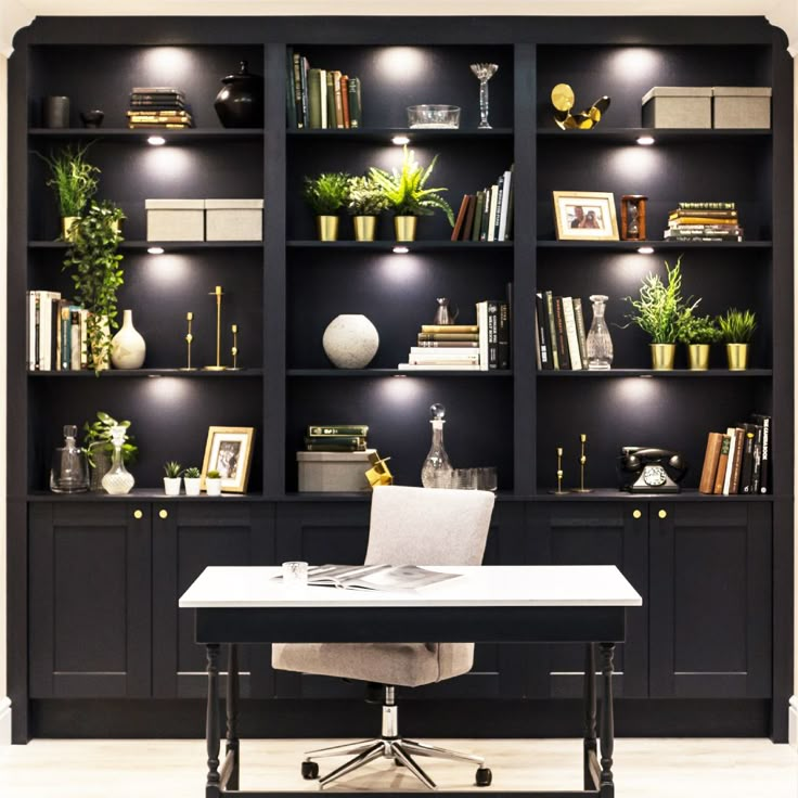 an office with black bookcases and white desk