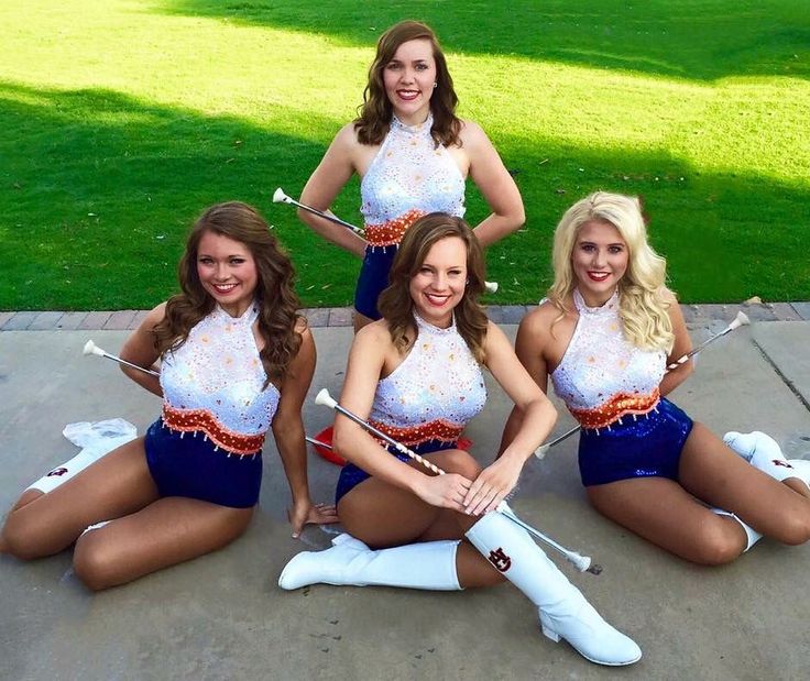 four beautiful women in cheerleader outfits posing for a photo with their bows and arrows