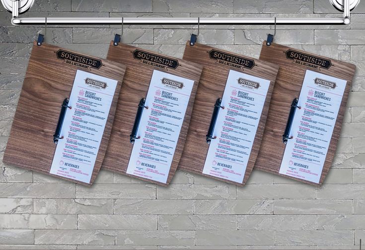 three wooden menu boards hanging on a brick wall