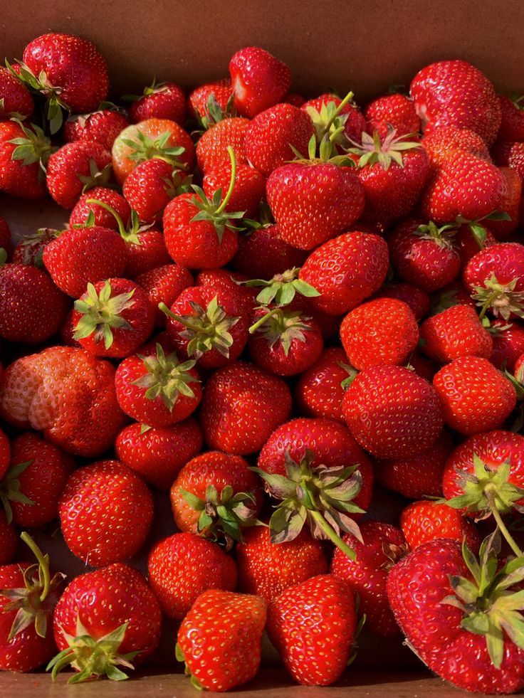 a box filled with lots of ripe strawberries