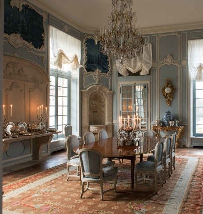 an ornate dining room with chandelier and blue painted walls, carpeted flooring