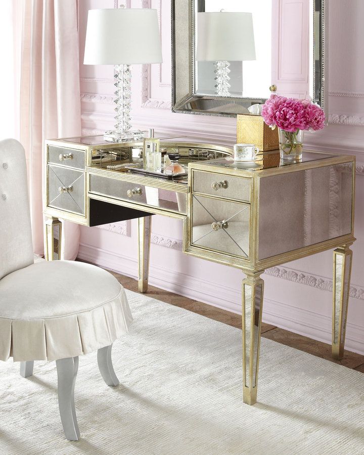 a white chair sitting in front of a desk with a mirror on top of it