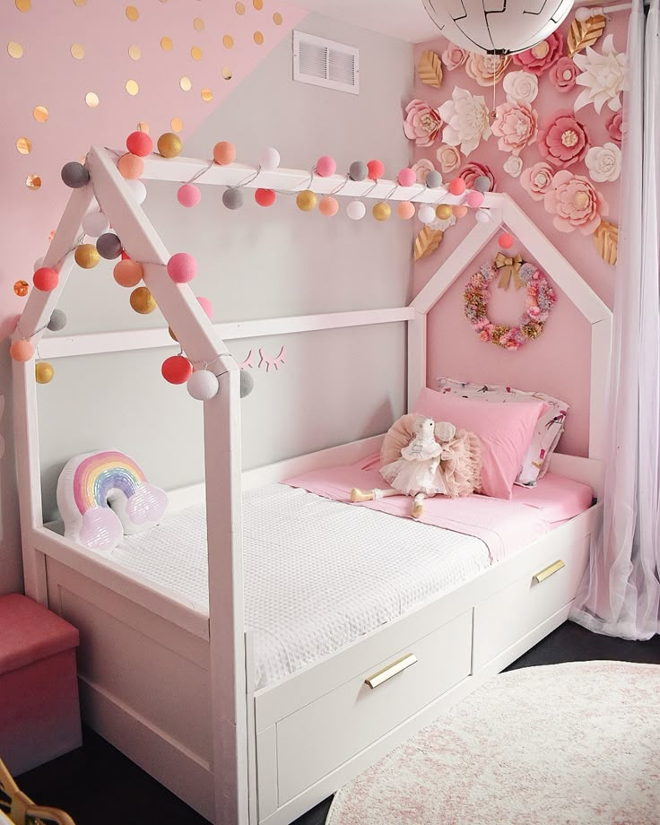 a child's bedroom decorated in pink, white and gold with a doll house bed