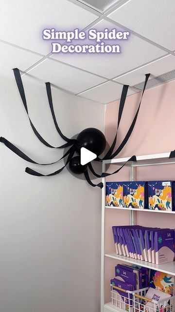 a spider decoration hanging from the ceiling in a children's room with bookshelves