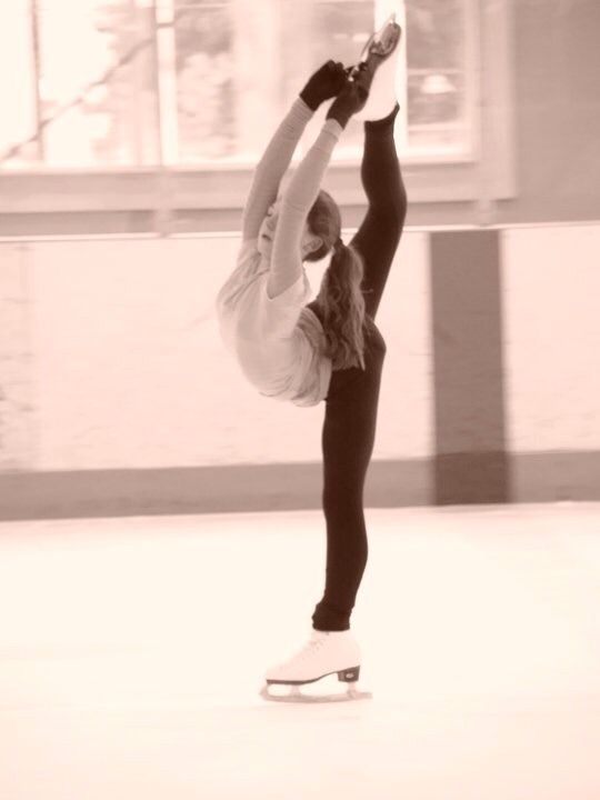 a woman is doing a handstand on a skateboard in an empty room