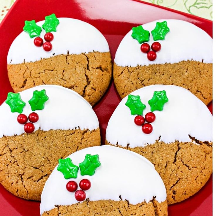 cookies decorated with holly and white frosting on a red plate